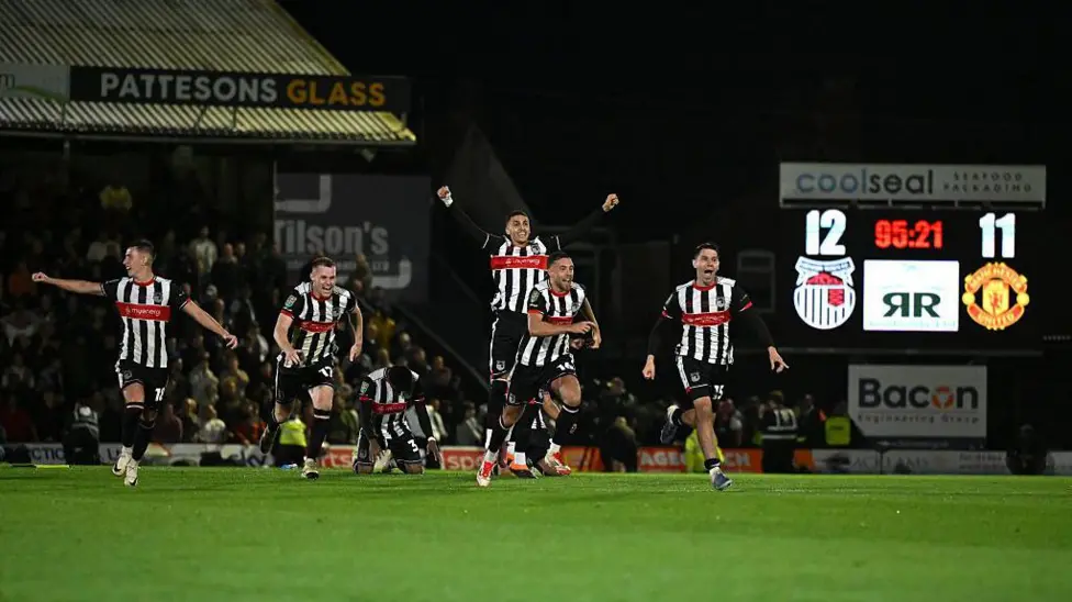 Dengan euforia yang meluap-luap, suporter Grimsby Town memadati lapangan usai tim mereka mengalahkan Manchester United.