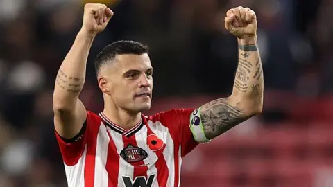 Dalam pandangan Wayne Rooney, kapten Sunderland Granit Xhaka layak disebut sebagai 